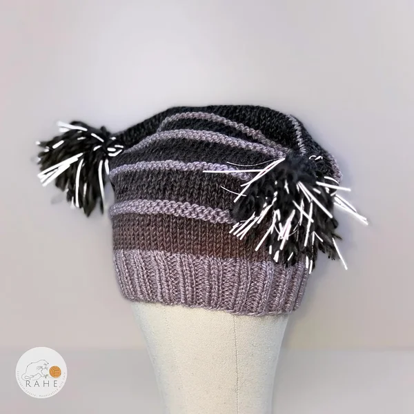 RAHEcraft hand-knitted reflective knit hat for kids and adults with striped design, ribbed brim, and reflective tassels.