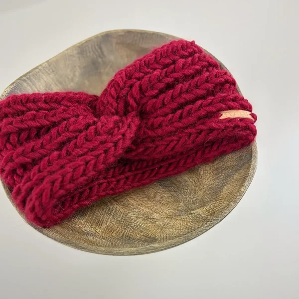 Flat view of red hand-knitted wool headband for girls and women by RAHEcraft