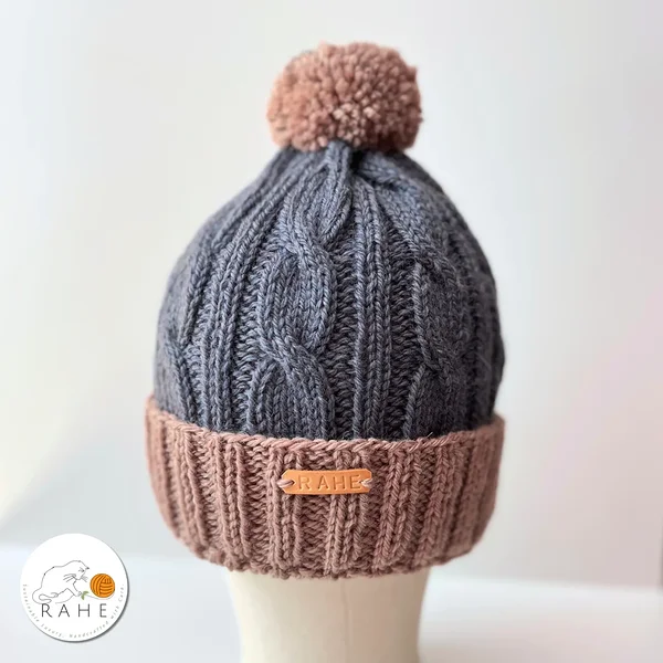 Side view of hand-knitted blue and beige wool beanie with reflective pom-pom – handmade hat suitable for kids, teens, women, and men.