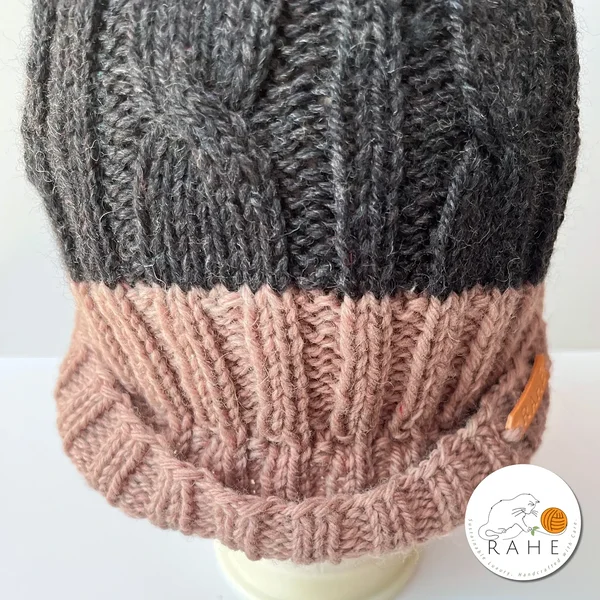 Side view of hand-knitted charcoal and beige-pink wool hat with reflective pom-pom – soft winter beanie for teens and women, handmade by RAHEcraft.