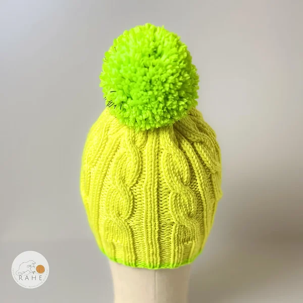 Neon yellow merino wool beanie for kids with a reflective pom-pom. Hand-knitted in Estonia for warmth, comfort, and visibility – a thoughtful handmade gift.