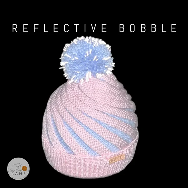 Kids pastel reflective pom-pom hat in soft pink and blue – hand-knitted merino wool beanie by RAHEcraft. Elegant and warm winter accessory from Estonia.