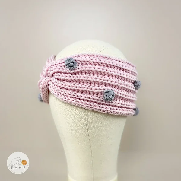 Hand-knitted merino wool headband in light pink with grey popcorn dots. Handmade gift idea for girls and ladies.