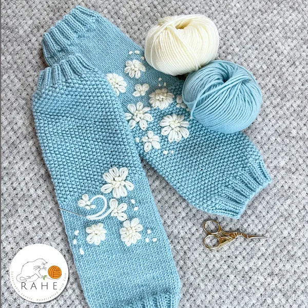 Soft and elegant light blue merino wool leg warmers – hand-knitted and hand-embroidered with white flowers, luxurious Estonian craftsmanship by RAHEcraft.